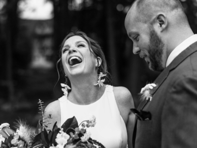 Couple at their wedding laughing while being photographed by their Wedding Photographer