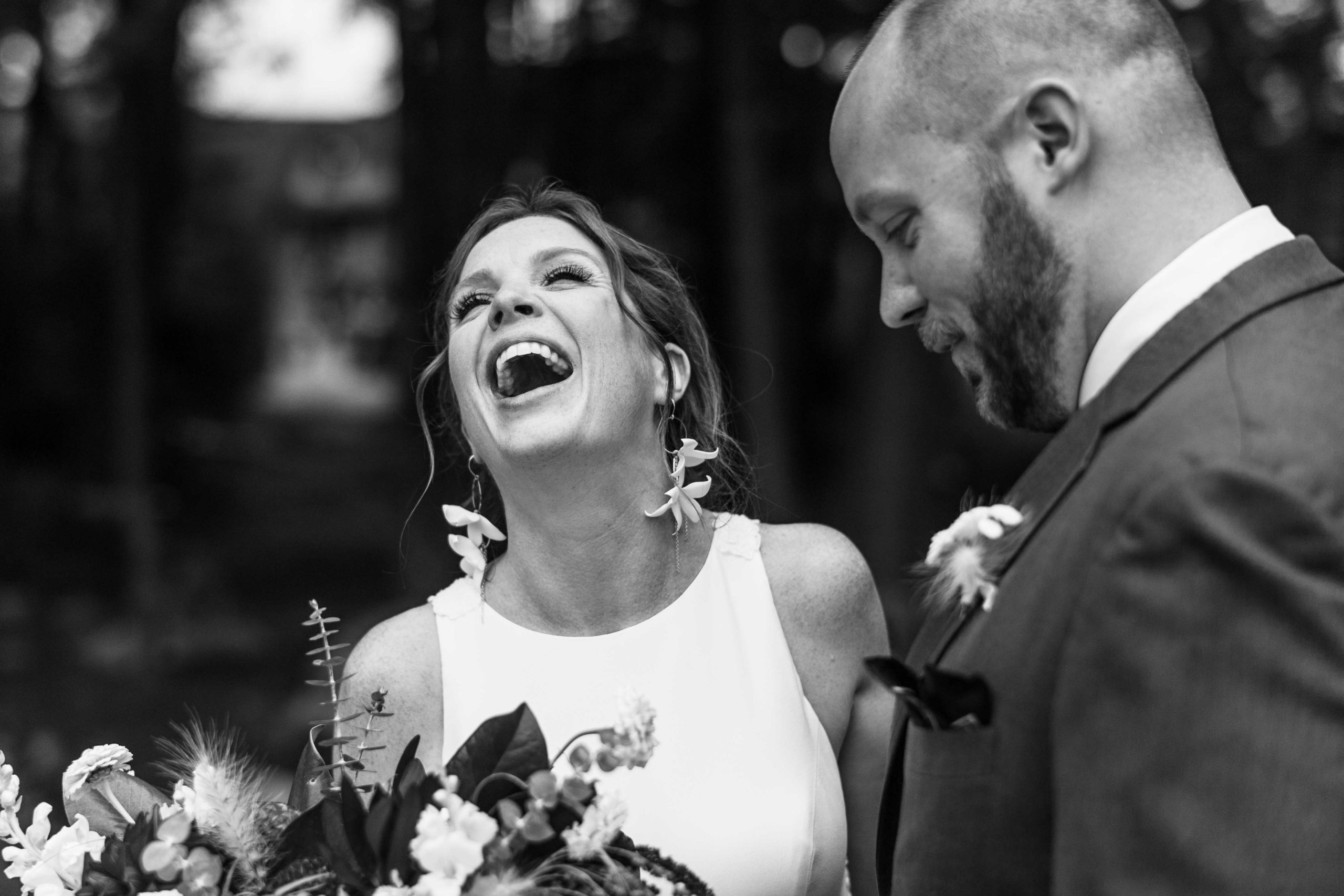 Couple at their wedding laughing while being photographed by their Wedding Photographer