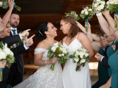 two brides celebrating with bridal party