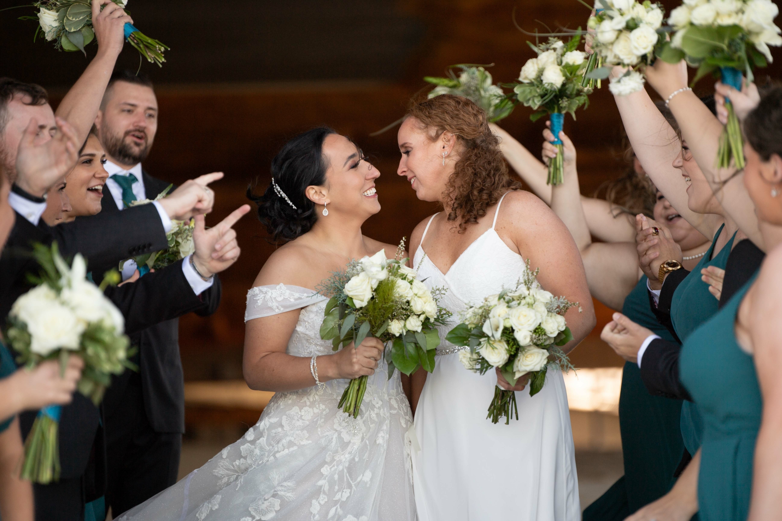 two brides celebrating with bridal party