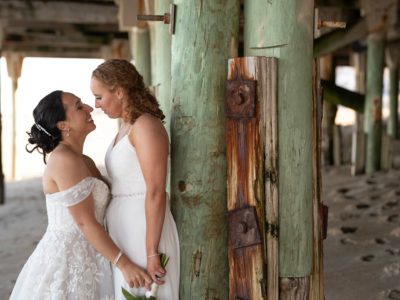two brides under the pier after wedding