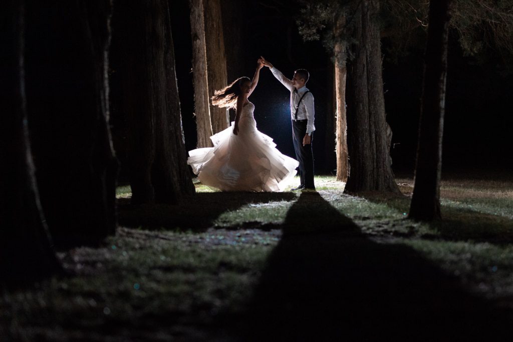 Bride and groom dancing in the woods after their wedding