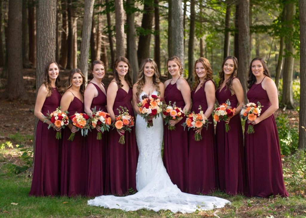 A bride poses with her bridesmaids holding bouquets.