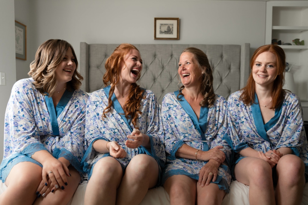 A bride with her bridesmaids and mother dressed in robes before the wedding