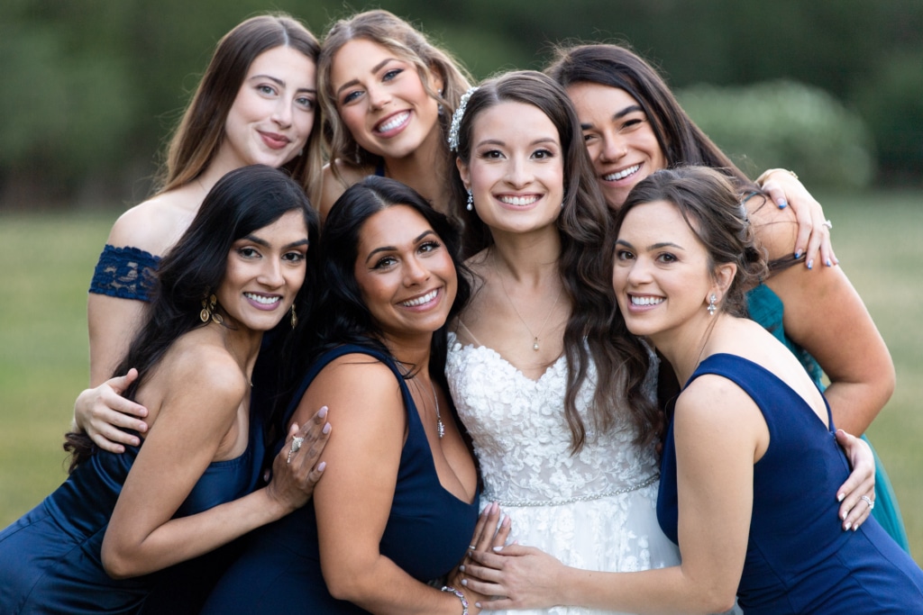 a bride surrounded by her smiling bridesmaids