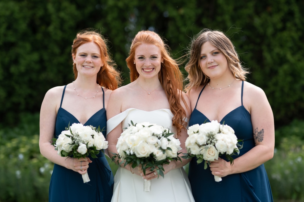 a bride and her two bridesmaids holding flowers