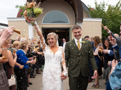 bride and groom exit church as guests toss flower petals